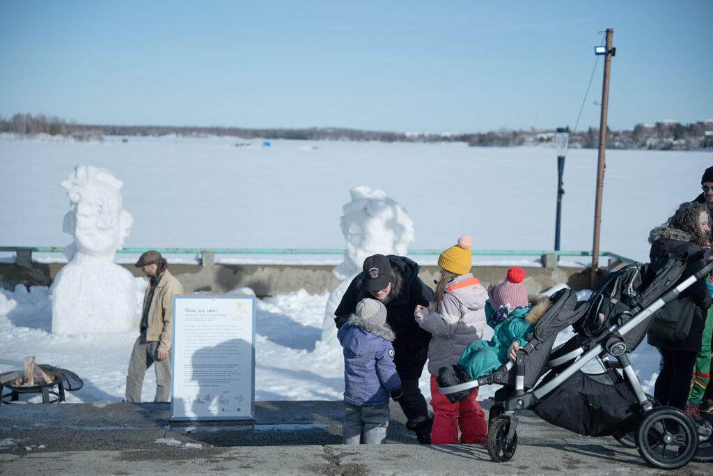 Gens assistant au 5 à 7 extérieur pour voir les sculptures et parler du projet.